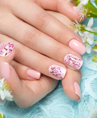 Spring manicure for the bride in gentle tones with flowers. Nail Design. Close-up.